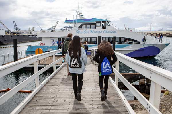 Students walking toward a boat wearing Port of LA backpacks.