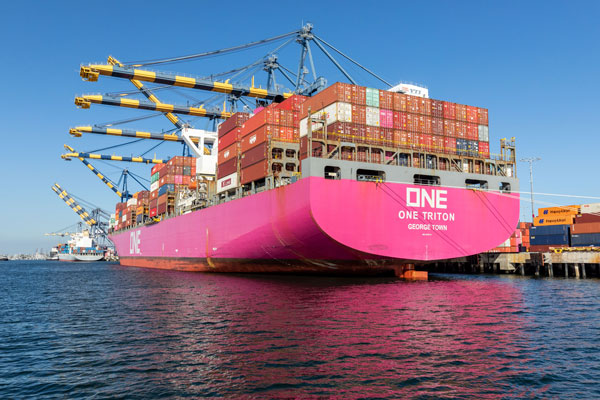 A bright pink ONE container ship docked at the Port of Los Angeles.